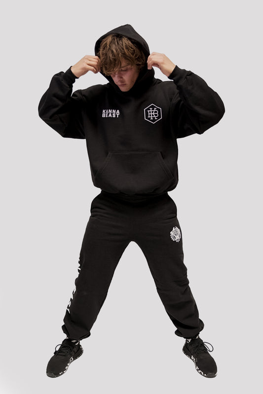 Male model with hands above head wearing Kanna Beast Hoodie and Sweatpants.