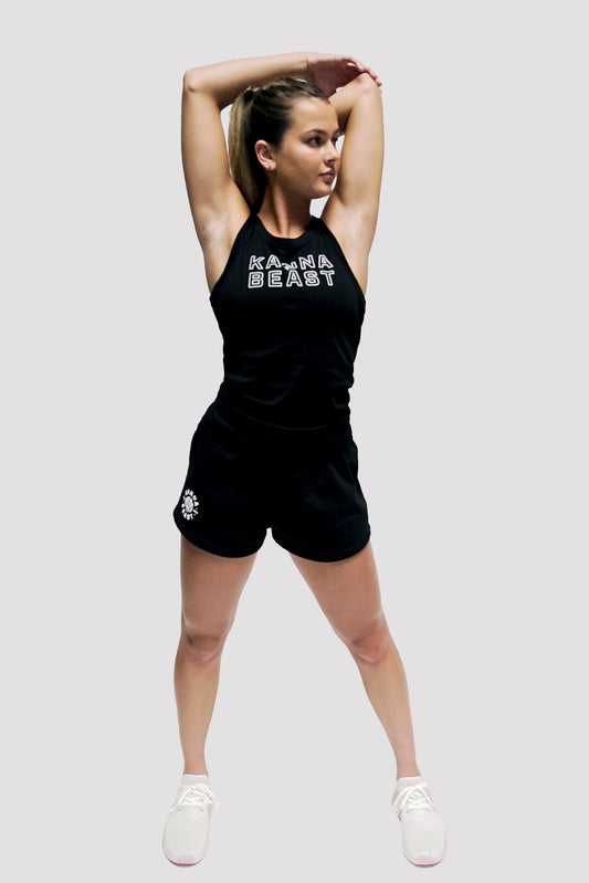 Model wearing Kanna Beast Tank Top posing with her arms above her head. Wearing black shorts and black tank top.
