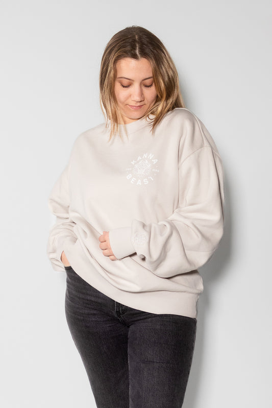 Female model wearing bone crewneck sweater with white lettering.