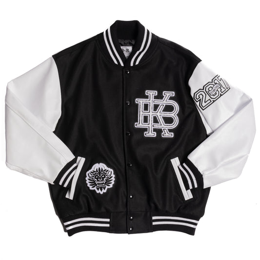 Flat lay image of Kanna Beast Letterman Jacket. With white leather sleeves, black wool body and three chenille patches of our logo, KB, and 2017 established year.
