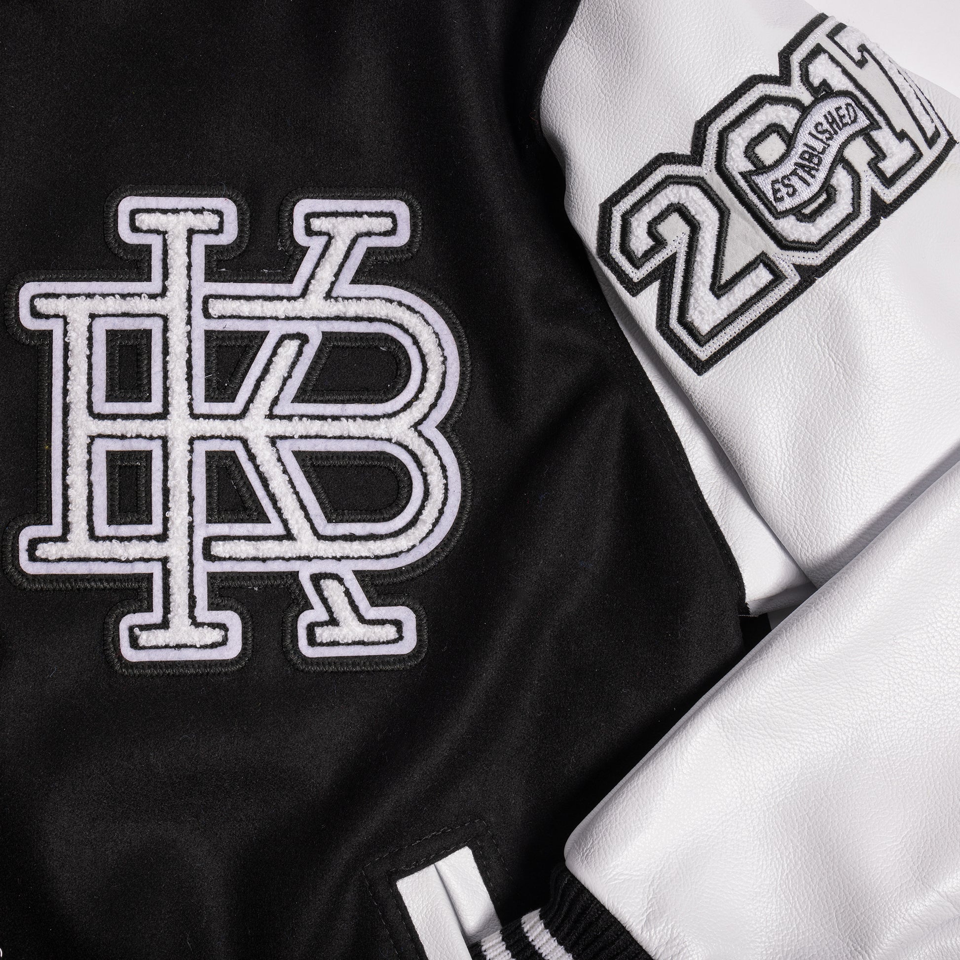 Close up image of left chest and left sleeve with KB lettering and "Established in 2017" chenille patches. 